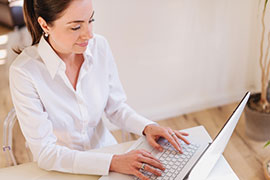 Janine Rietdorf sitzt vor einem Laptop am Tisch