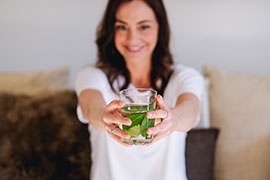 Janine Rietdorf hält ein Glas Minztee in den Händen